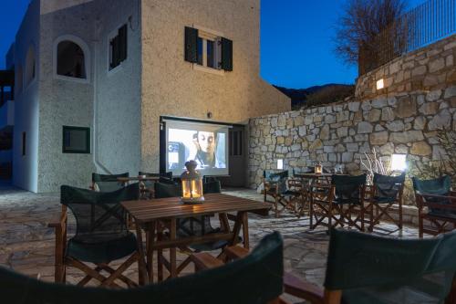 een patio met tafels en stoelen en een scherm bij Akti Apollona in Apollon