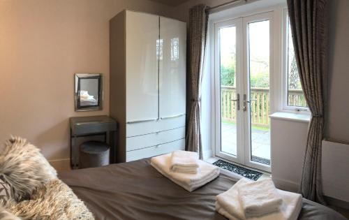 sypialnia z łóżkiem i dużym oknem w obiekcie Treetops w mieście Newton Poppleford