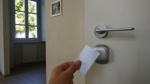 a person holding a piece of paper in front of a door at Casa di ALTAVILLA in Alba