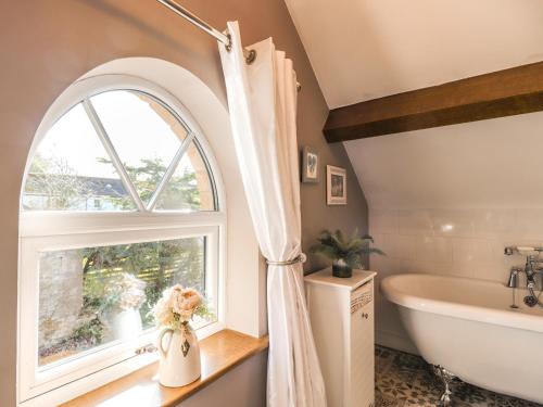 a bathroom with a window and a tub and a sink at Stanley Barn in Brampton