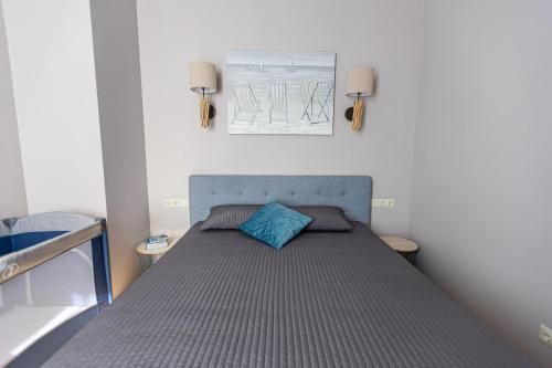 a bed with a blue pillow on top of it at Jomas street apartment in Jūrmala