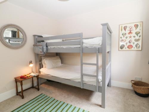 a bedroom with two bunk beds and a table at 1 Castle Cottages in Exeter