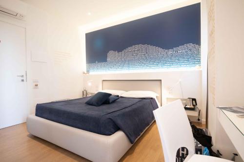 a bedroom with a bed with a large picture on the wall at F53 Kevin's Charming Houses in Alghero