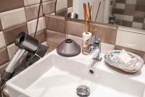 a bathroom sink with a blow dryer and a plate at F53 Kevin's Charming Houses in Alghero