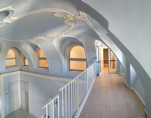 a white staircase with a white ceiling and windows at Casa di ALTAVILLA in Alba