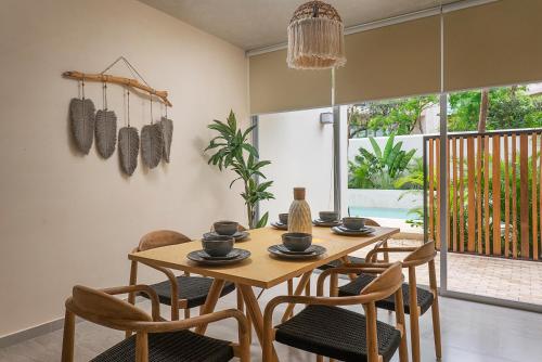 une salle à manger avec une table et des chaises en bois dans l'établissement 1BR Apartment with Private Pool and Rooftop Access Tulum A103, à Tulum