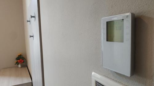 a white refrigerator with a mirror on a wall at Casa di ALTAVILLA in Alba