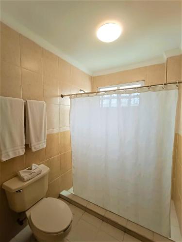 a bathroom with a toilet and a shower curtain at Hotel Santo Domingo Express in Villahermosa