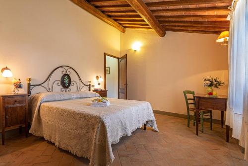 a bedroom with a bed and a table and a mirror at Agriturismo Casavaiano in Gambassi Terme