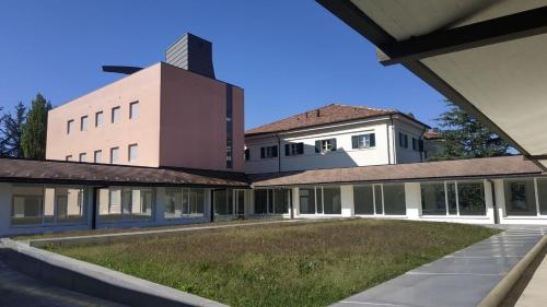 a building with a grass yard in front of it at Casa di ALTAVILLA in Alba