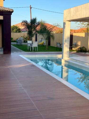 a house with a swimming pool and a patio at Gabz Airport Inn in Gaborone
