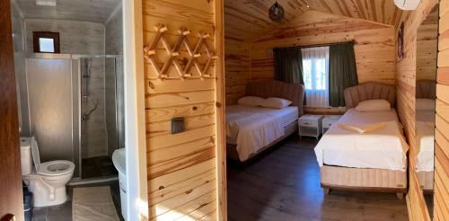 a bedroom with two beds and a shower in a cabin at mercan pension in Olympos