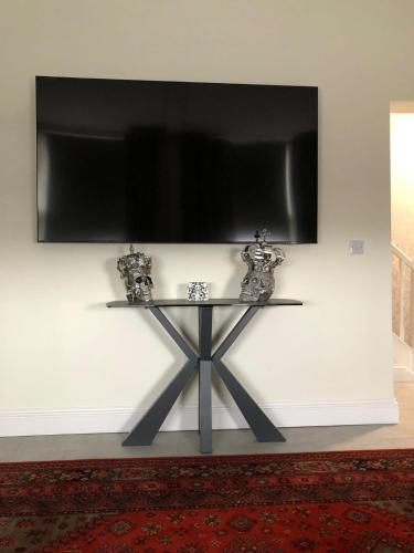 a table with a flat screen tv on a wall at Ten Streets Bed & Breakfast in Liverpool