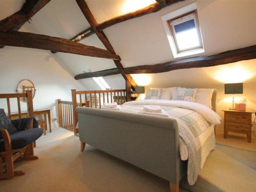 a bedroom with a large bed in a attic at Butlers Cottage in Burford
