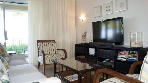 a living room with a couch and a tv at Villa Renaissance Grace Bay in The Bight Settlements