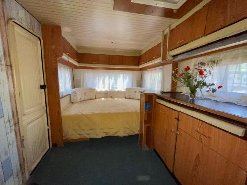 a small bedroom with a bed in the middle at Караваната На Морето in Sozopol