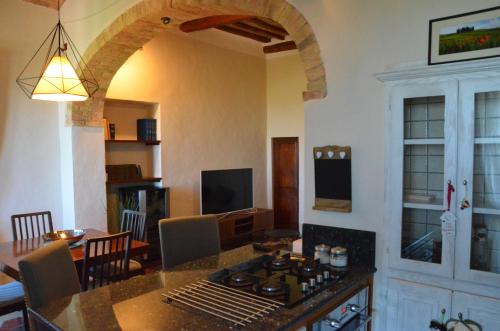 a kitchen and living room with a table and a dining room at La Terrazza sull'Alba in Montalcino