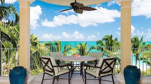 a patio with a table and chairs and the ocean at Villa Renaissance Grace Bay in The Bight Settlements