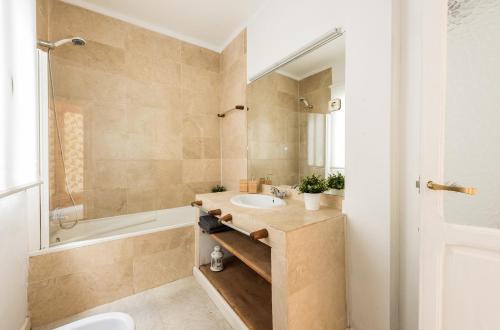 La salle de bains est pourvue d'un lavabo, d'une baignoire et de toilettes. dans l'établissement Living Plaza de la Paja, à Madrid