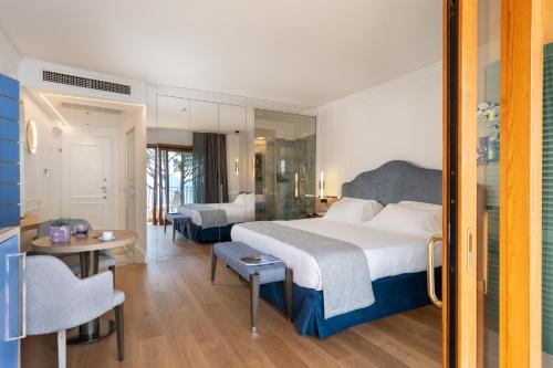 a hotel room with a large bed and a table at Golfo dei Poeti Relais & Spa in Ameglia