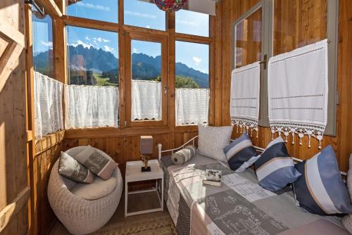 a room with a bed and a couch and a window at Zenana Boutique Hotel in San Candido