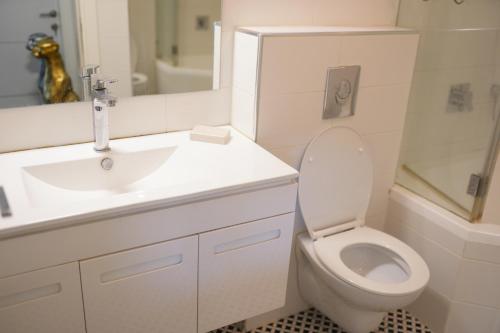 a white bathroom with a sink and a toilet at Cancun in Netanya