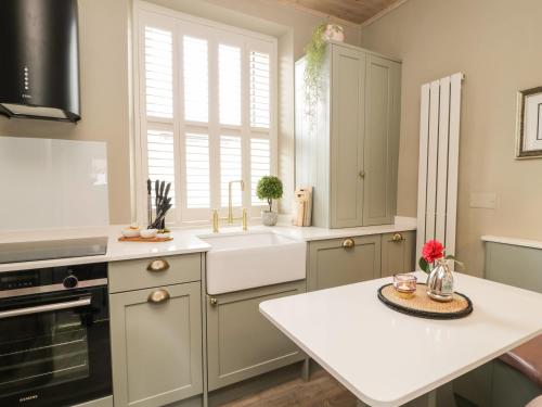 a kitchen with a sink and a white counter top at Hideaway Cottage in Penrith
