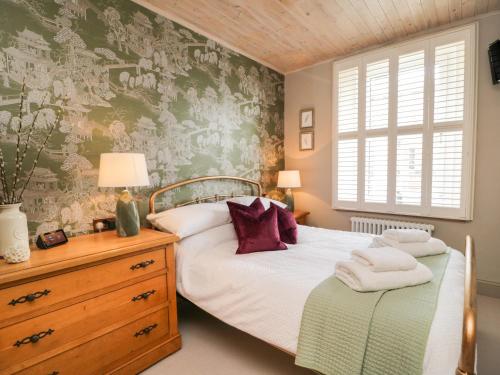 sypialnia z 2 łóżkami i malowidłem ściennym w obiekcie Hideaway Cottage w mieście Penrith