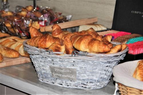 a basket of croissants and other pastries on a counter at L'Hôtel du Marais Romilly Centre in Romilly-sur-Seine