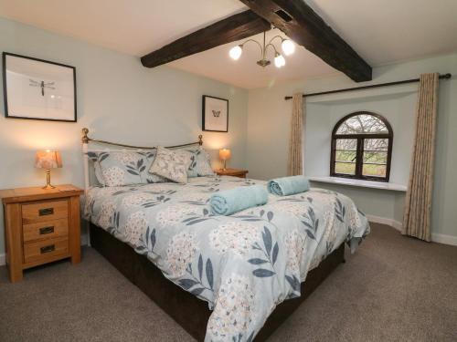 a bedroom with a bed and a window at Barn Owl Cottage in Minehead
