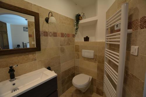 a bathroom with a toilet and a sink and a mirror at La Villa des Moulins in Calvisson
