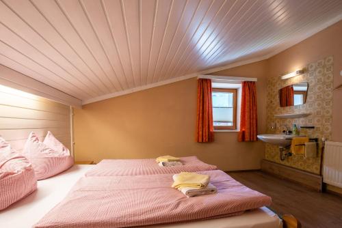 a bedroom with a large bed and a sink at Apartment Zwölferblick in Vorderkrimml