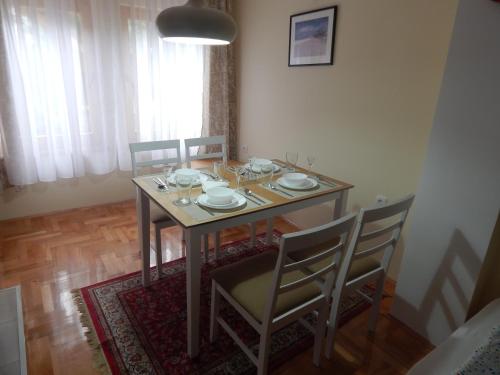 a dining room table with chairs and a table and a table and chairsktop at Apartmani Jelica FREE PARKING in Vranje