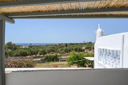 a view from the balcony of a house with a view of a field at kleris apartments 8 in Tinos Town