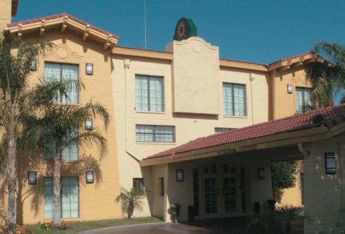 a building with palm trees in front of it at La Quinta Inn by Wyndham Bakersfield South in Bakersfield