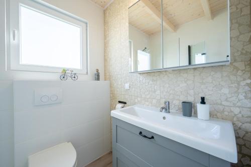 een witte badkamer met een wastafel en een spiegel bij Saint Wicie in Darłowo