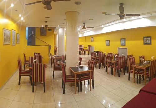 un ristorante con tavoli, sedie e pareti gialle di Hotel Tres Sargentos a Buenos Aires