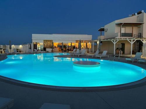 a large swimming pool with blue water at night at DEL REY in Paralia Katerinis