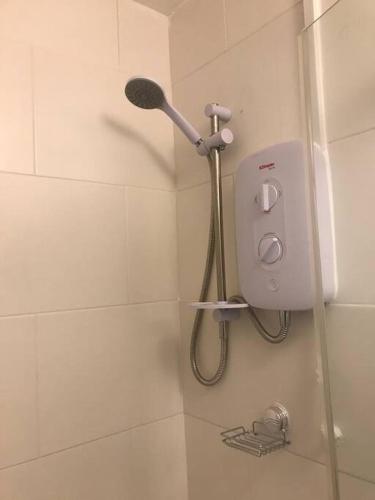 a shower in a bathroom with a shower head at Abbotts Mews Apartment York City Centre in York