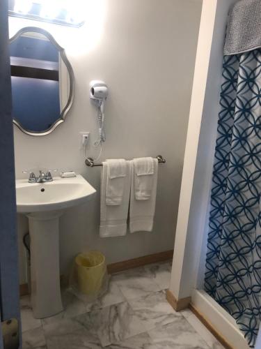 y baño con lavabo, espejo y toallas. en Executive Motel en Old Orchard Beach
