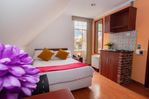 a bedroom with a bed with yellow pillows at ApartaSuites & Hotel Bogota Plaza 36 in Bogotá