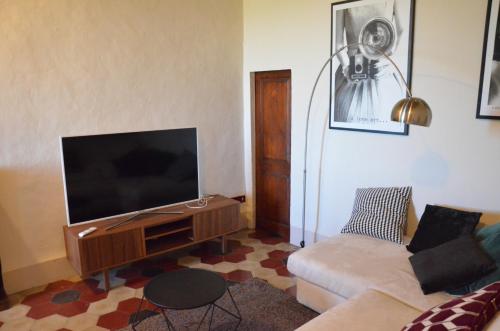 a living room with a couch and a flat screen tv at La Terrazza sull'Alba in Montalcino