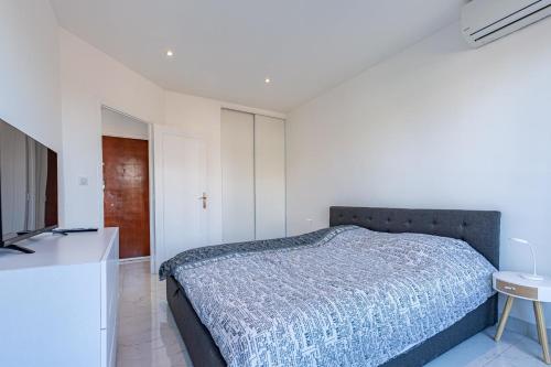 een slaapkamer met een bed en een flatscreen-tv bij BNB Renting one bedroom apt completely renovated behind the Martinez hotel in Cannes