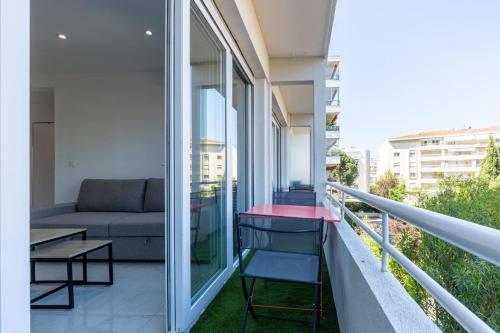 - un balcon avec un canapé et une table dans un bâtiment dans l'établissement Le Cirodde one bedroom apt completely renovated behind the Martinez hotel, à Cannes