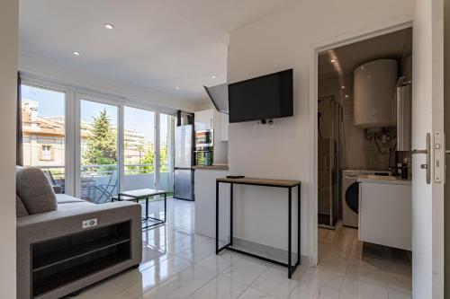 een keuken en een woonkamer met een bank en een televisie bij BNB Renting one bedroom apt completely renovated behind the Martinez hotel in Cannes