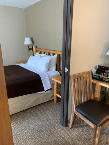 a bedroom with a bed and a chair and a mirror at The Antler Lodge - Gardiner in Gardiner