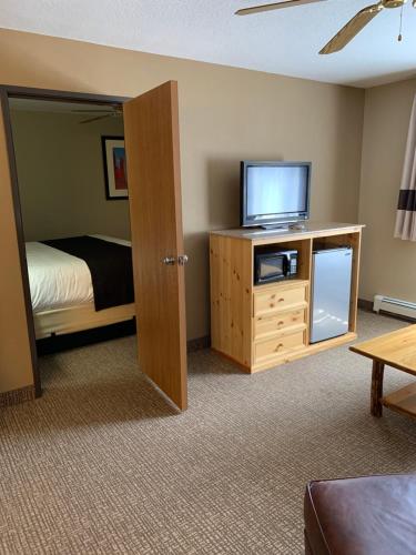 a bedroom with a bed and a television on a cabinet at The Antler Lodge - Gardiner in Gardiner