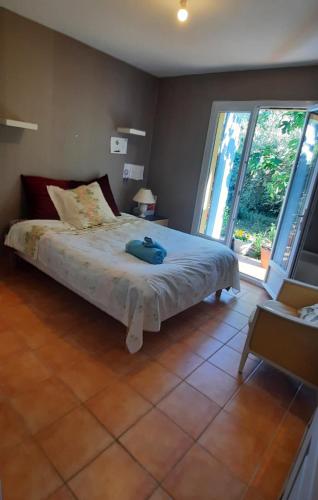 une chambre avec un lit et une grande fenêtre dans l'établissement Jardin d'amis, à Collobrières