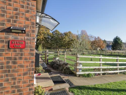 a brick building with a sign that reads stupid car at Stubb Oak in Malvern Wells