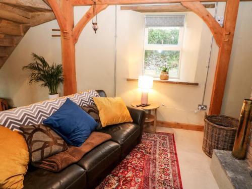 a living room with a leather couch and a rug at Lehane's Cottage in Macroom